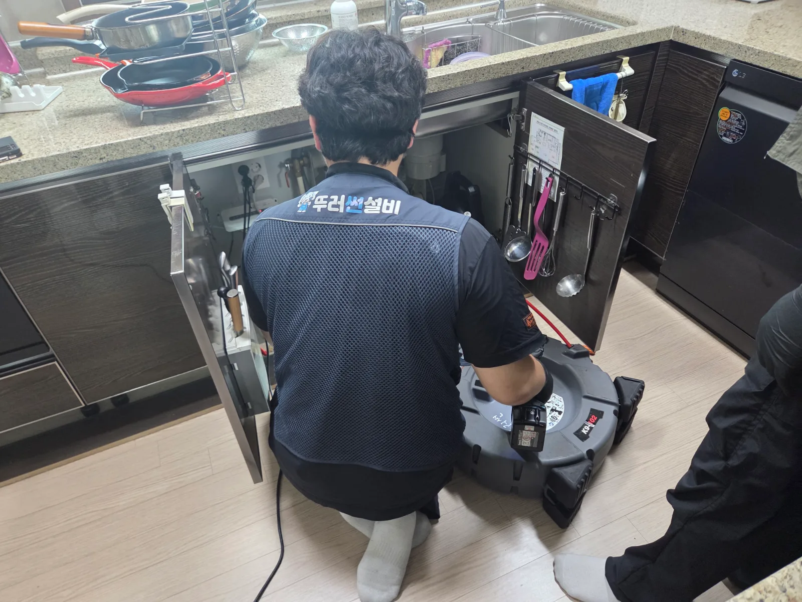싱크대 앞에 배관 세척 장비를 배치한 작업 과정