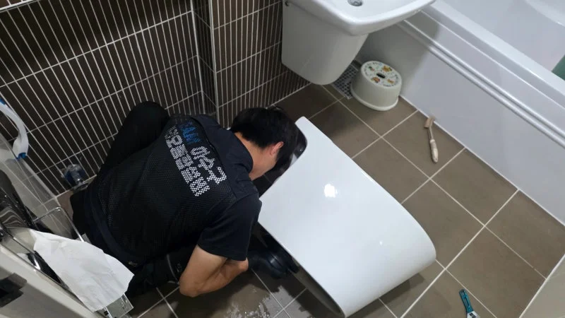변기 하부를 확인하며 고정 작업을 진행하는 모습