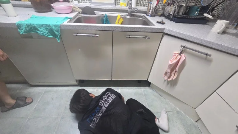 도화동 싱크대 하부장 바닥과 연결부를 살피는 모습